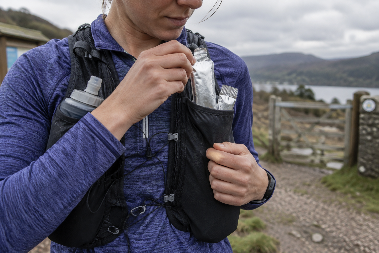 Runner placing unbranded energy gel sachets into front pockets of a running vest